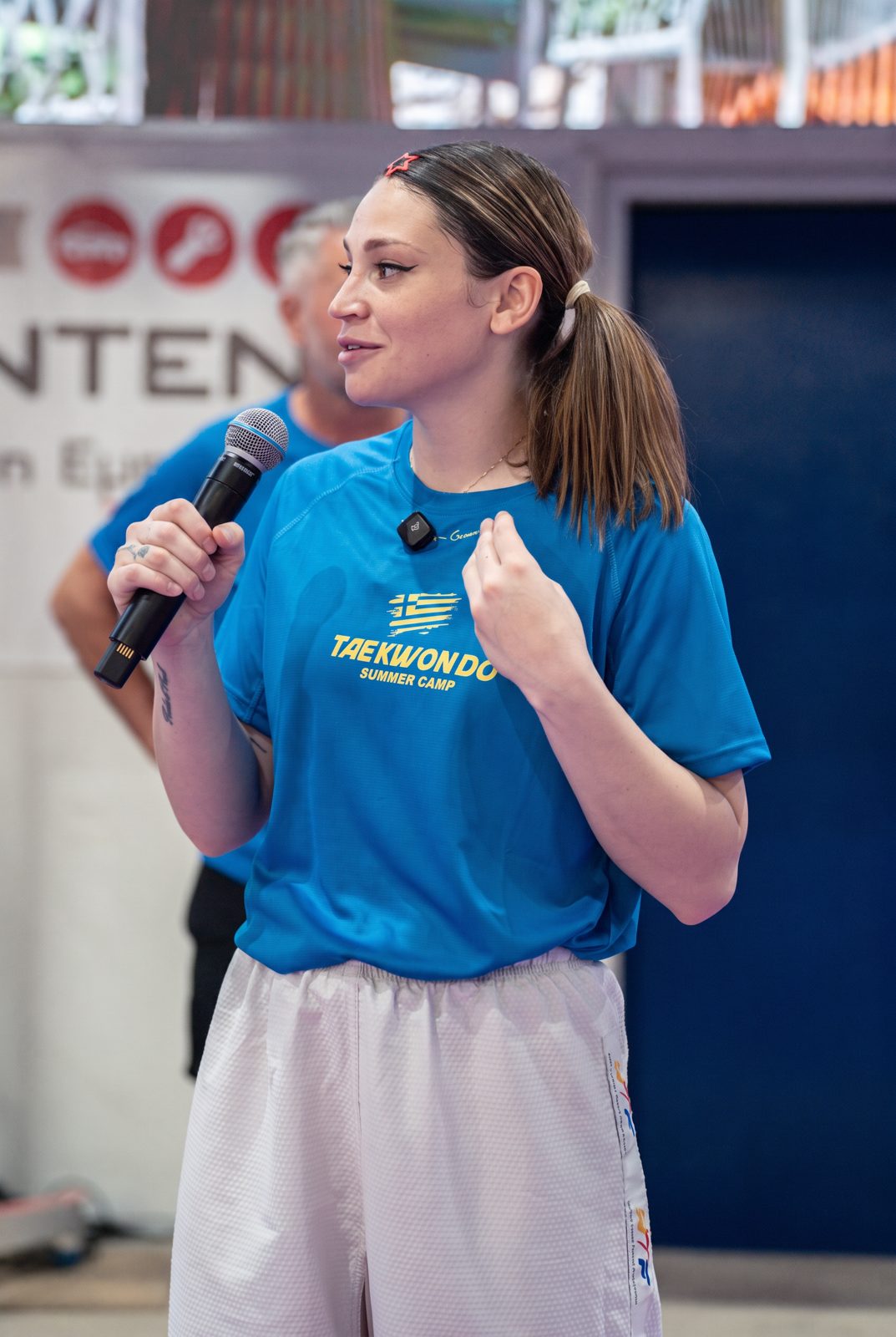 Carolena coaching athletes with a microphone at a taekwondo camp